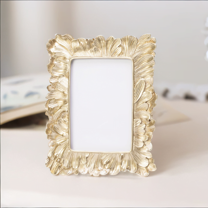 A gold frame adorned with delicate leaves, adding an elegant touch to any artwork or photograph.