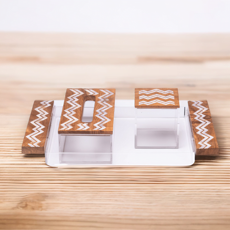 a mother of pearl set with zigzag pattern, includes Tray, tissue box and a cube storage box sitting on a wooden table.