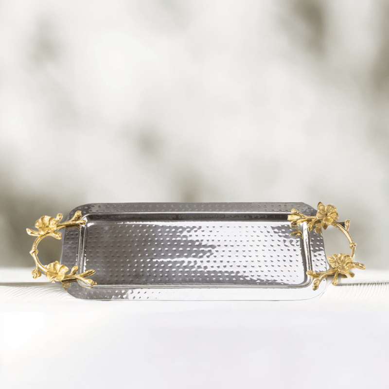 Rectangle hammered stainless steel serving tray adorned with gold handles on a white surface.