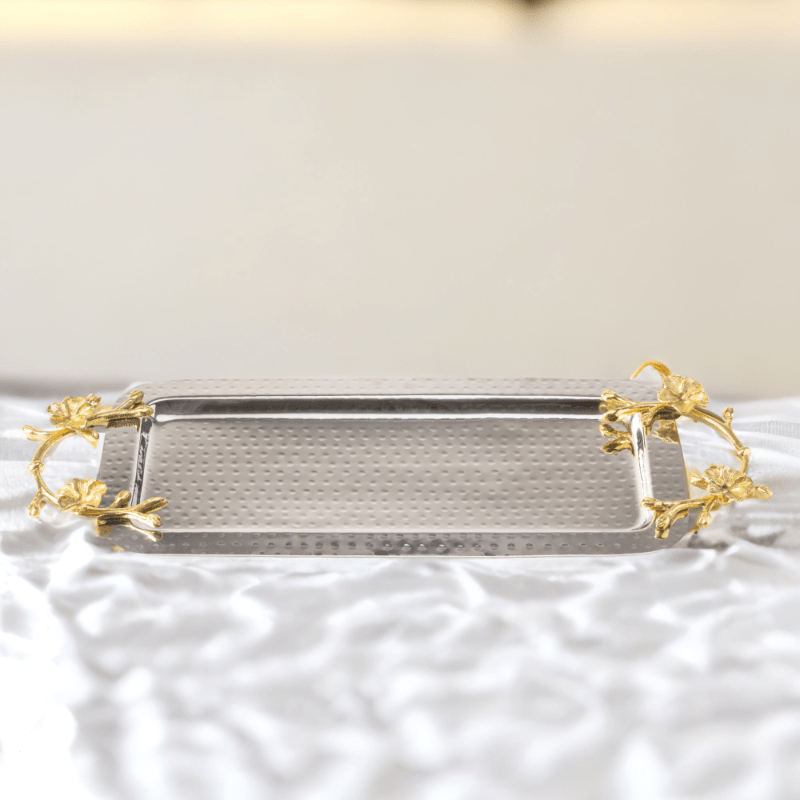 A Long Floral Tray with gold handles on a white table.
