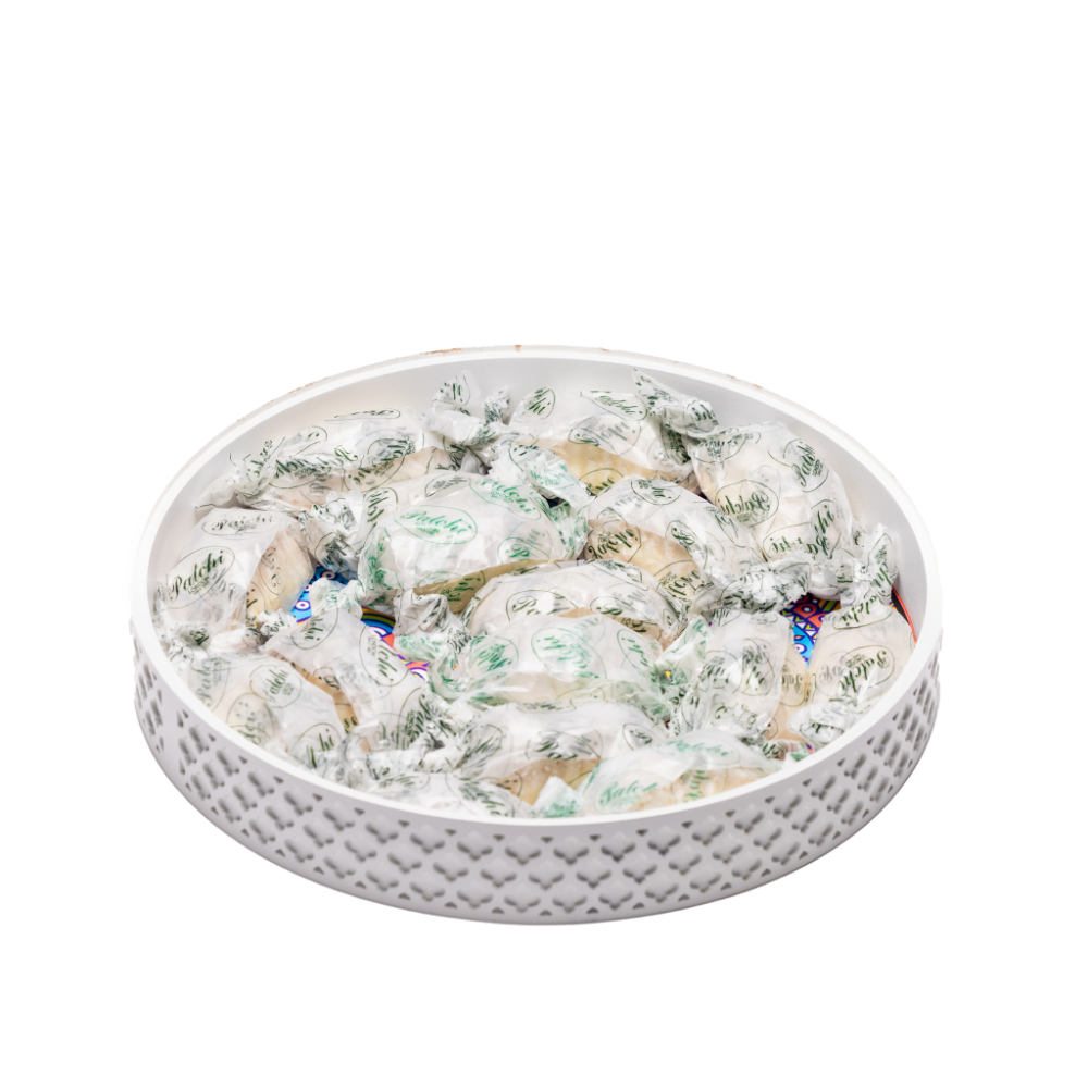 a white decorative tray filled with ramadan sweets.