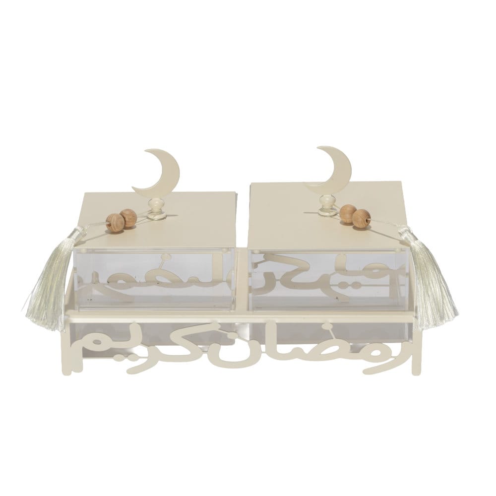 off white metal serving stand with Ramadan Kareem calligraphy cutout, holding two clear lidded acrylic boxes with tassel details.